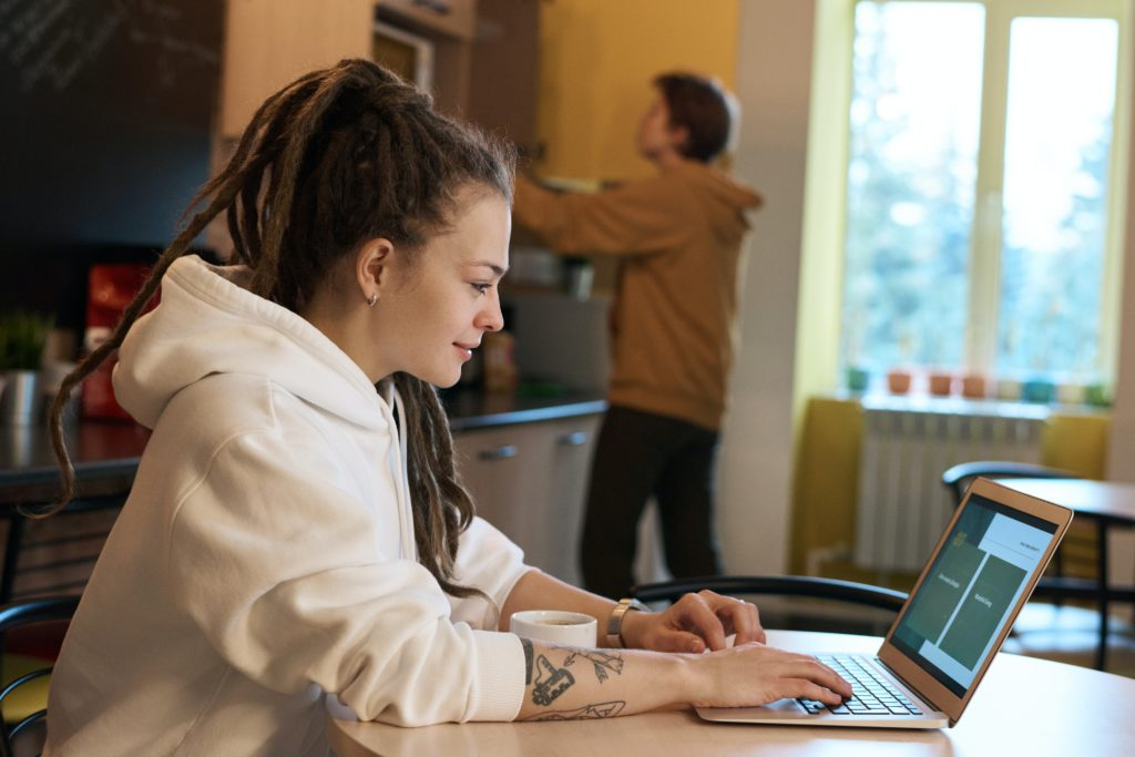 Person setting up a comfortable and well-lit home office for effective remote work